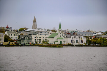 Fototapeta premium View of the city centre of Reykjavik with the Hallgrimiskirkja Church seen from Lake Tjoernin - Iceland
