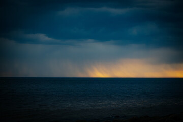 Dark ominous sea with sunset on the horizon in spring. Soft selective focus. Artificially created...