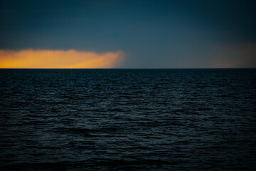 Dark ominous sea with sunset on the horizon in spring. Soft selective focus. Artificially created...