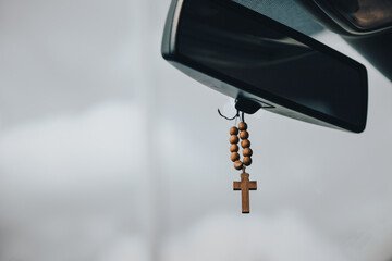 wooden rosary on the inside mirror of the car  - 800496658