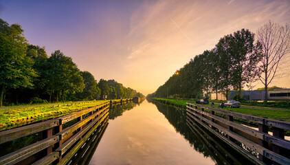 Sunset over the still waters of the Wilhelminakanaal canal in Noord-Brabant, The Netherlands.