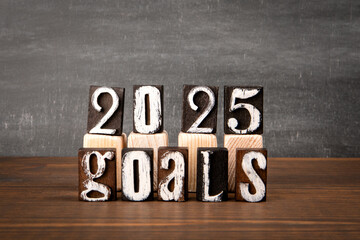2025 Goals Concept. Alphabet blocks on wood texture background