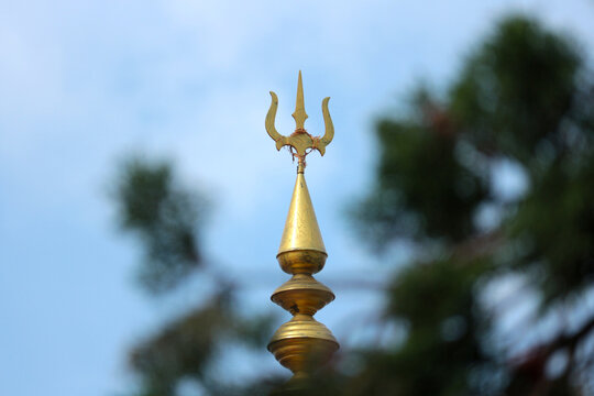 Golden spire of a Hindu temple with a trident.