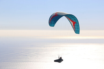 Paraglider flying over the sea