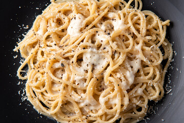 Primo piano di spaghetti con cacio e pepe, ricetta tradizionale di pasta romana con pecorino e pepe nero, cibo italiano 