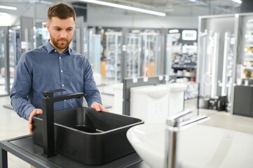 Man choosing bathroom sink and utensils for his home