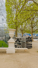 Springtime in Paris, France, featuring fresh green trees and event preparations with stacked chairs on April 14th, 2024ideal for urban spring and cultural events themes