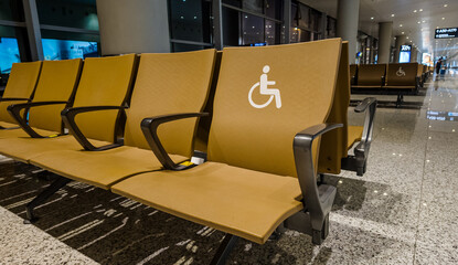 Accessible seating in a modern airport waiting area designated with a disability symbol, showcasing...