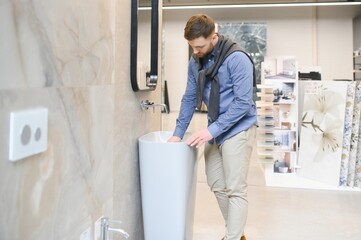 Man choosing bathroom sink and utensils for his home