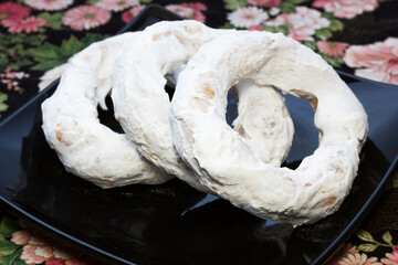 Three cotudos on a black plate. Colombian pastry candy of indigenous origin in the donut shape.