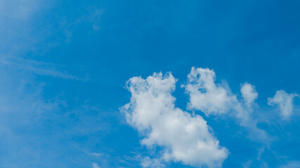 Expansive blue sky with soft white clouds, ideal for concepts of freedom, summer weather, and...