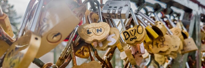 Assorted love locks on a fence symbolizing eternal love, commonly seen in romantic travels and...
