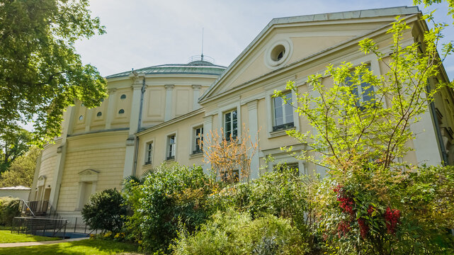 Classic European architecture of a historic mansion surrounded by lush greenery, ideal for content related to heritage buildings, history, and cultural tourism