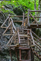 Beautiful wooden hand-made bridge in the eco path. - obrazy, fototapety, plakaty