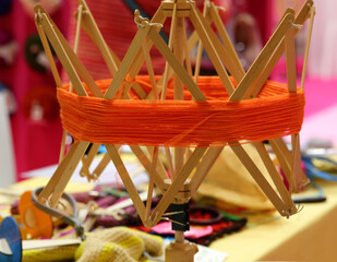 spindle for creating orange wool elbows in the artisanal knitwear factory