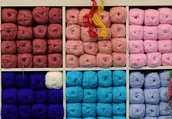 display of yarn balls on wooden shelves and they are neatly stacked in rows