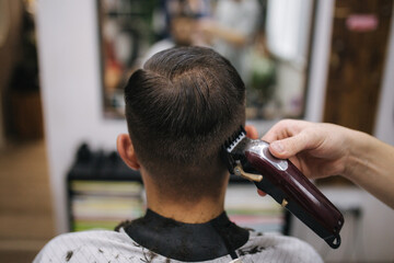 Back view of Men in beauty salon. Men's haircut in a barbershop. New haircut style 2024....