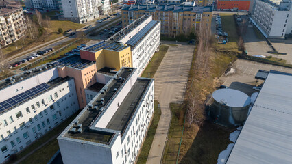 Drone photography of multistory houses, streets and sidewalks in a city during spring day