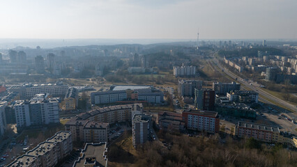 Drone photography of multistory houses, streets and sidewalks in a city during spring day