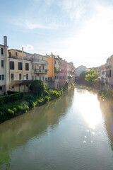 Afternoon summer sun over medieval old town landscape of Padova, Italy, with river Bacchiglione in...