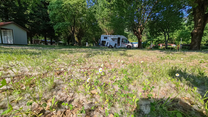 A campground in Medveja, Croatia. There are some bungalows on the side and some camper vans in the...