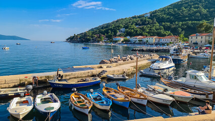 A small marina full of boats parked along it in Moscenicka Draga, Croatia. Calm surface of the...