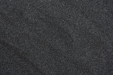 Pile of black quartz sand as background, top view. Crushed quartz.