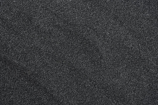 Pile of black quartz sand as background, top view. Crushed quartz.