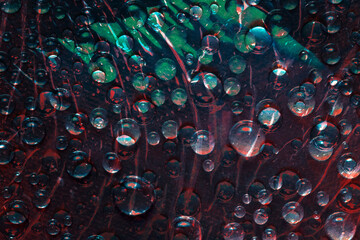 Green and red raindrops falling down against the turquoise background. Abstract fantasy. 3D render.