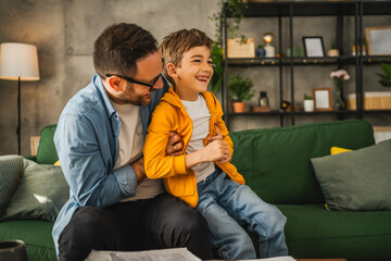 Dad and son tickle and have fun at home