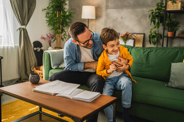 Dad and son tickle and have fun at home