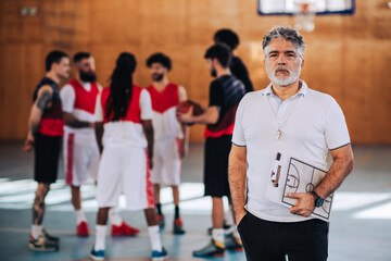 Portrait of a mature confident male coach posing with a coach clipboard