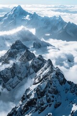 Fototapeta premium Stunning visual of rugged mountains with snow caps peaking through the soft clouds, conveying a sense of tranquility and power