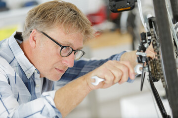 mature competent bicycle mechanic in a workshop