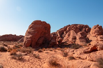 Panoramic view of red Aztek sandstone rock formations in Petroglyph Canyon along Mouse Tank hiking trail in Valley of Fire State Park in Mojave desert, Nevada, USA. Hot temperature in arid vegetation
