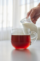 Pouring Cream into a Cup of Coffee