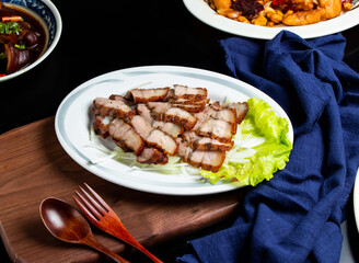 Grilled Salted Pork with spoon and fork served in dish isolated on wooden board side view of taiwan food