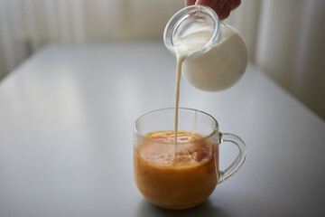 Pouring Cream into a Cup of Coffee