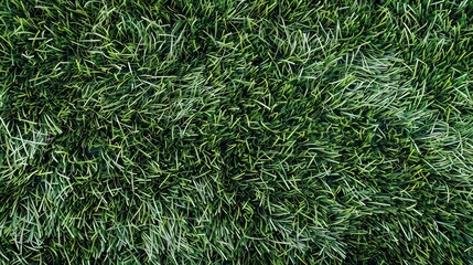 A top-down close-up of a vibrant green synthetic grass surface, typically used in soccer pitches, showing detailed texture and uniformity.

