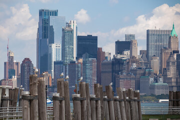 A wooden pier on the Hudson River with captivating New York urban skyline with striking and modern...