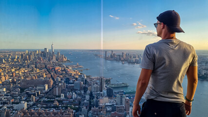 A man in a cap standing at the observatory deck of The Edge with captivating aerial view of New...