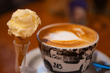 Flat white coffee with a small scoop of vanilla ice cream.