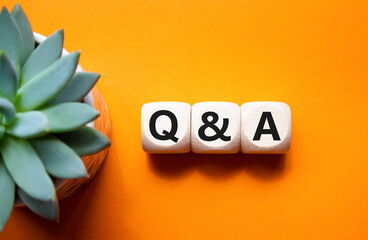 Q and A - Question and Answer. Wooden cubes with words Q and A. Beautiful orange background with...