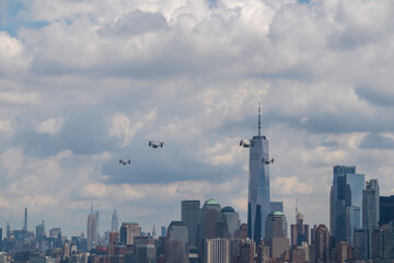 A formation of drones flying across the sky with captivating New York urban skyline with striking...