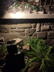 Petit coin de jardin, de décoration, en pleine nuit, avec peu d'éclaire, petite fontaine...
