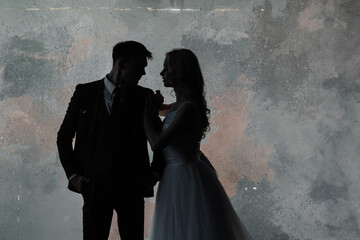 Art fashion studio photo of wedding couple silhouette groom and bride on colors background. Art...
