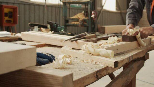 A woodworker is hard at work using a plane