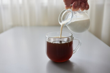 Pouring Cream into a Cup of Coffee