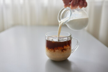Pouring Cream into a Cup of Coffee