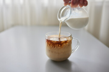 Pouring Cream into a Cup of Coffee